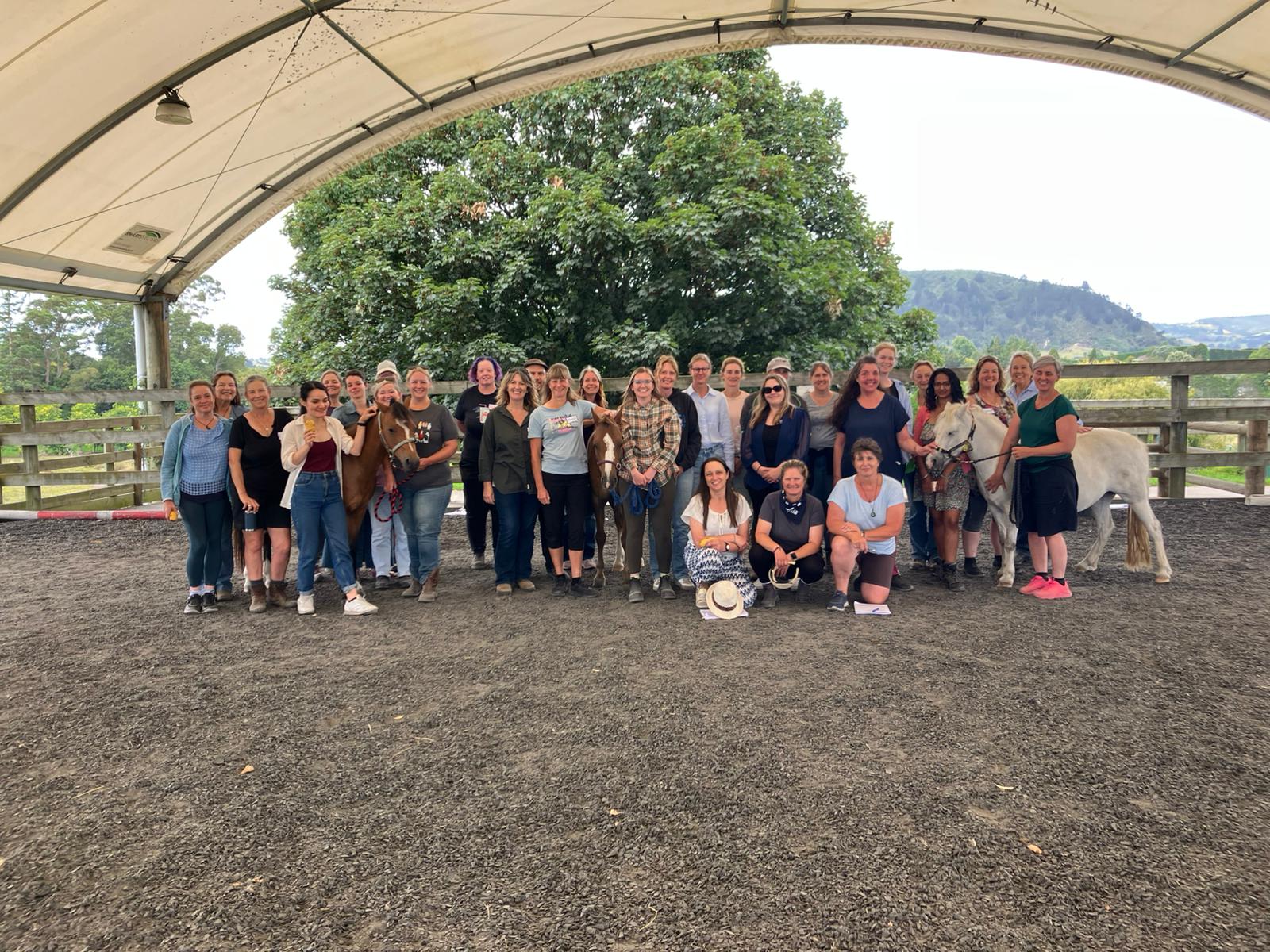A group picture in a covered arena during new Zealand fundamentals training.